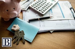 Calculator, tax forms, and house keys used to estimate the NJ exit tax on a home sale